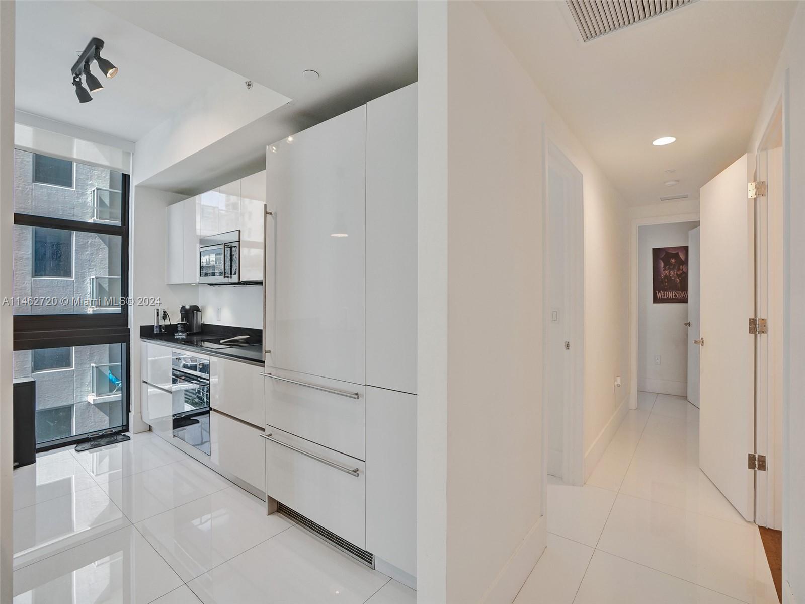 1010 Brickell Avenue, Unit 2505 Miami, FL 33131 - Photo 4 of 61 a kitchen with white cabinets and white appliances