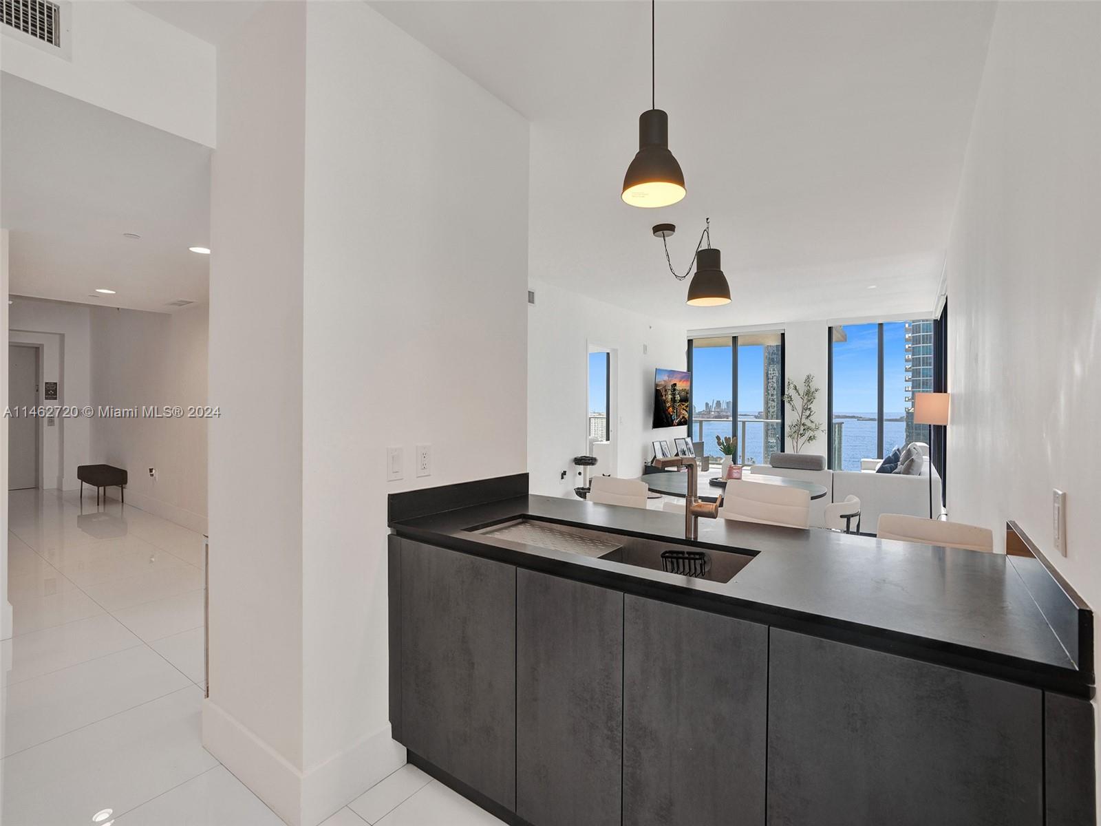 1010 Brickell Avenue, Unit 2505 Miami, FL 33131 - Photo 5 of 61 a dining hall with couches a chandelier fan and kitchen view