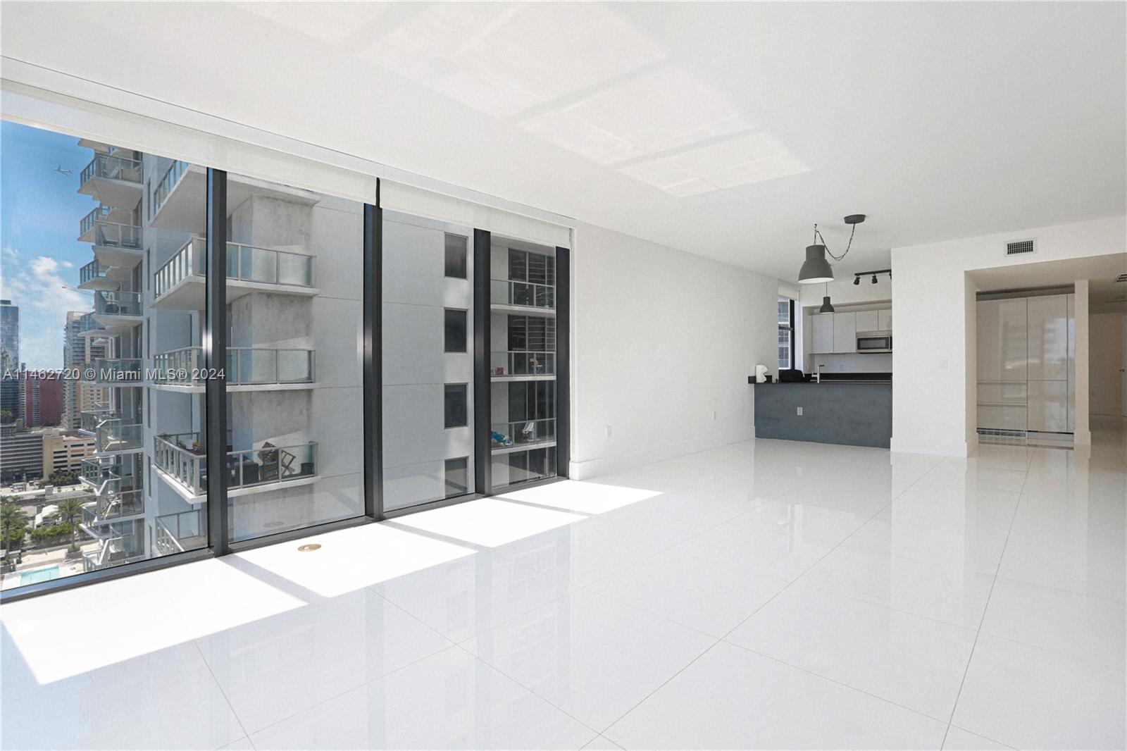 1010 Brickell Avenue, Unit 2505 Miami, FL 33131 - Photo 55 of 61 a large white kitchen with granite countertop a refrigerator and a stove