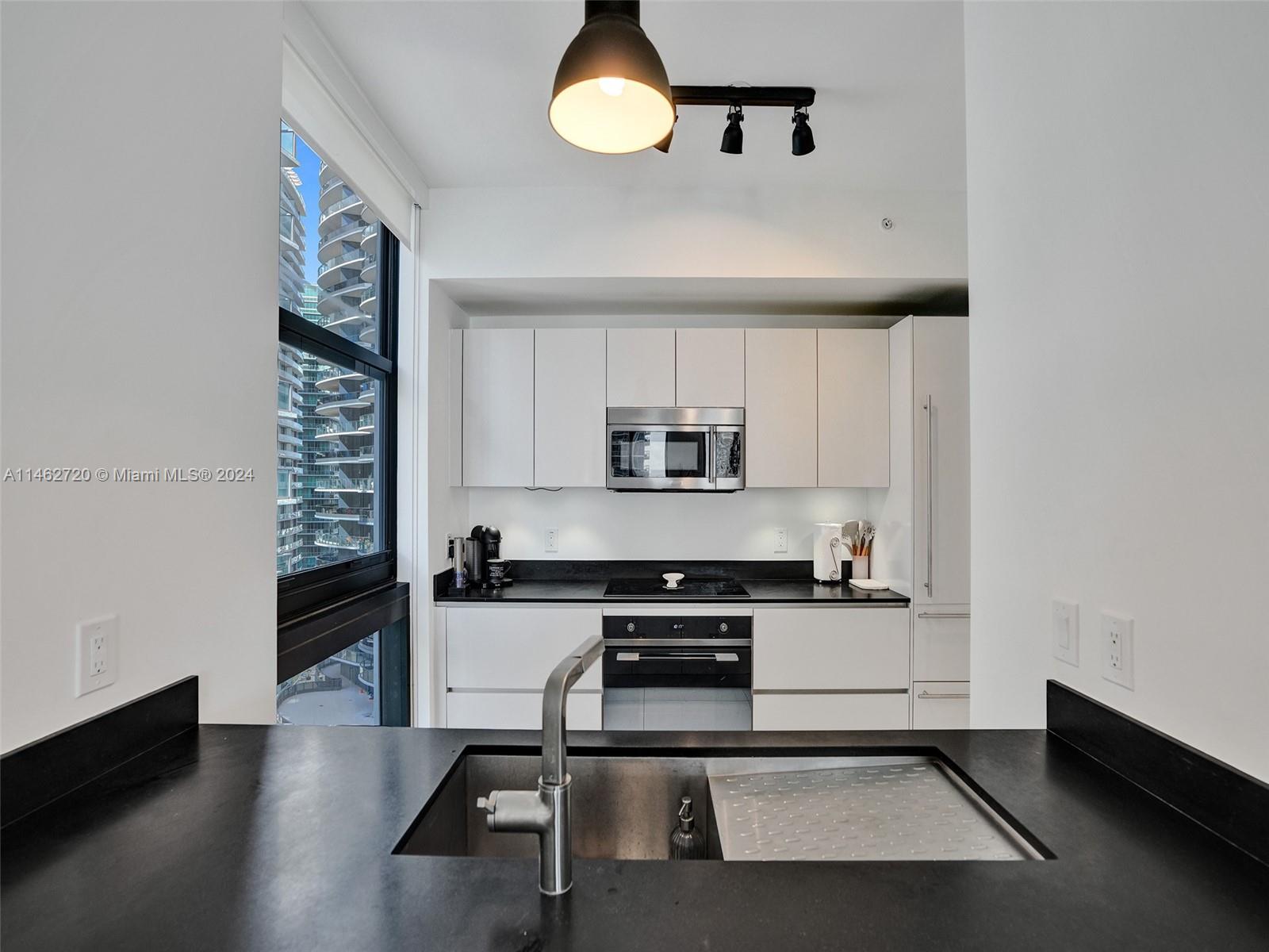 1010 Brickell Avenue, Unit 2505 Miami, FL 33131 - Photo 6 of 61 a kitchen with stainless steel appliances a stove a refrigerator and cabinets