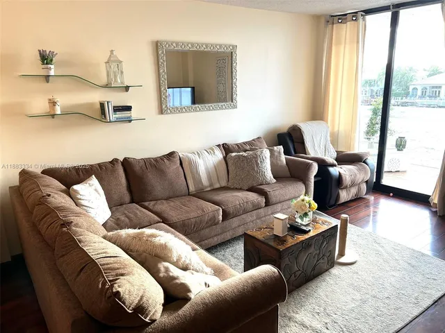 a living room with furniture wooden floor and a large window