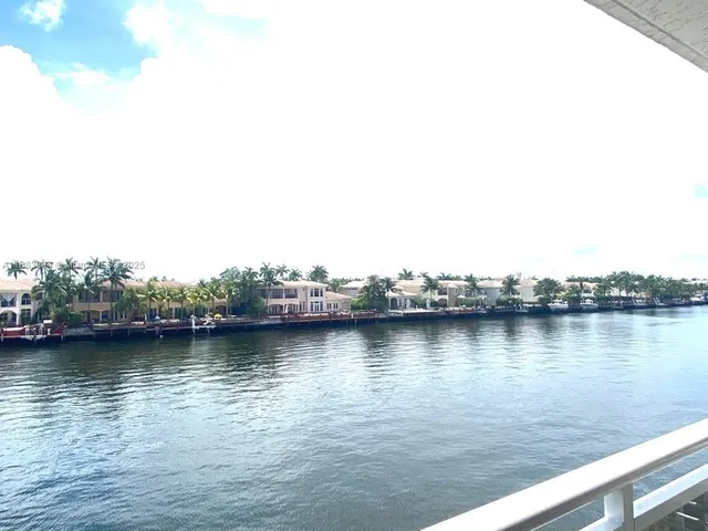 a living room with furniture a mirror and a potted plant