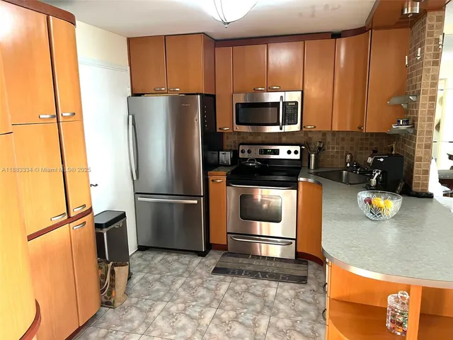 a kitchen with stainless steel appliances a refrigerator sink and stove
