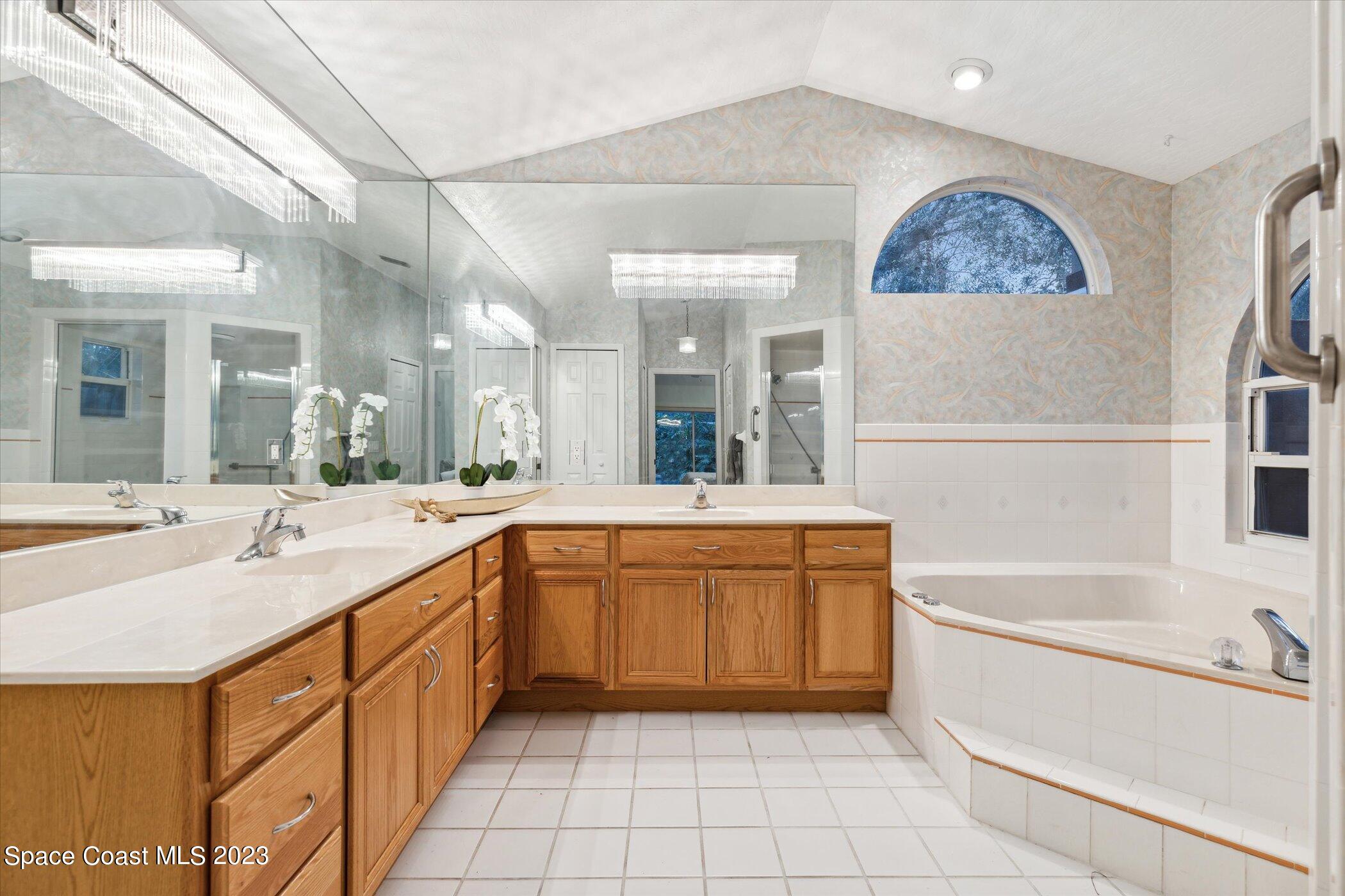 4644 Canard Road Melbourne, FL 32934 - Photo 24 of 42 a spacious bathroom with a tub sink and mirror