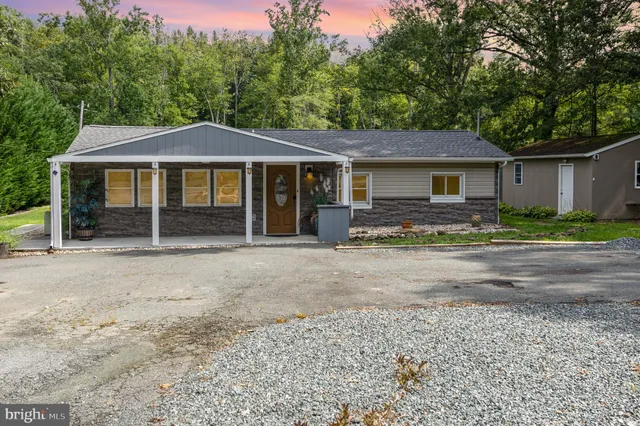 a front view of a house with yard patio and tree