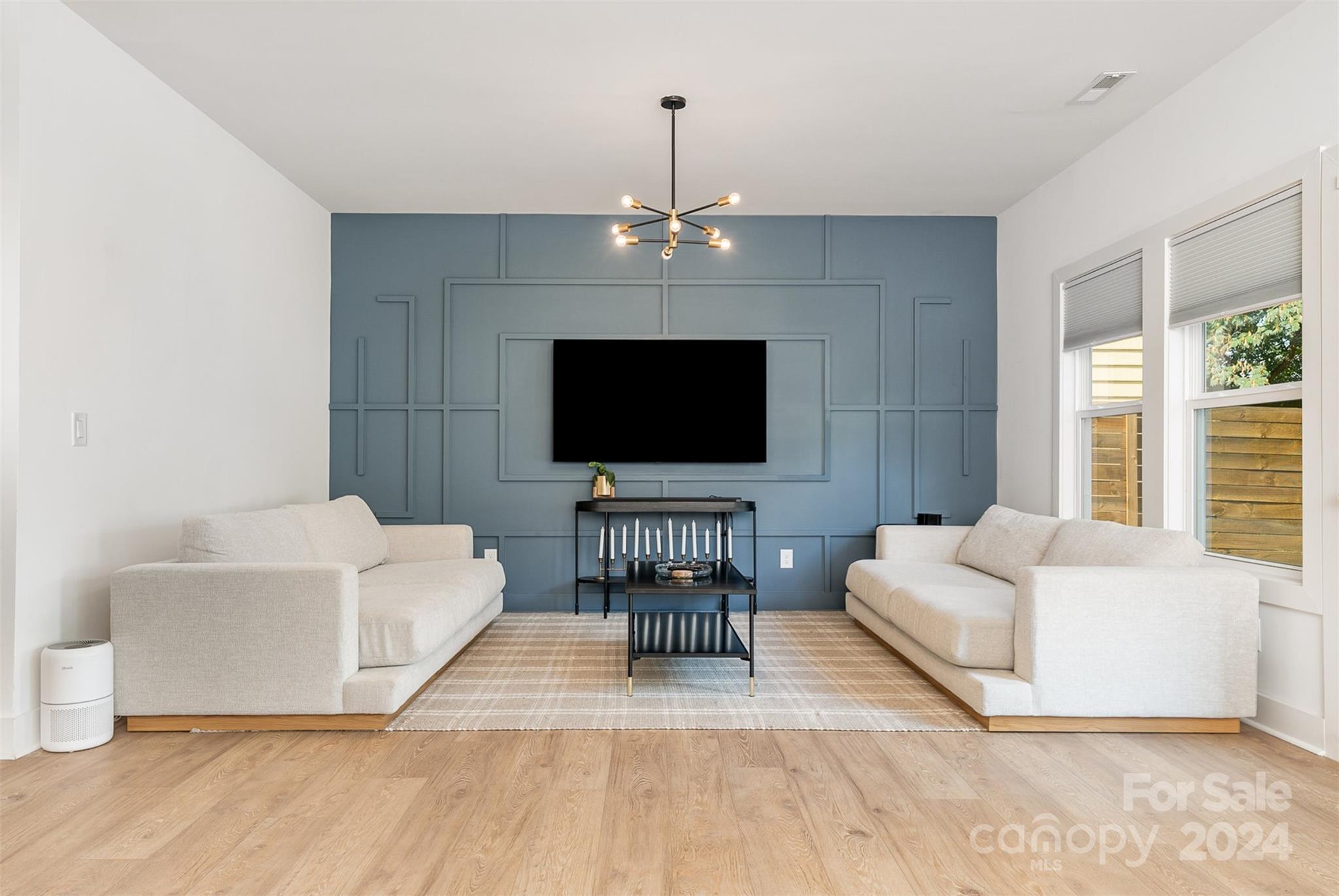 643 Tennyson Drive Charlotte, NC 28208 - Photo 32 of 42 a living room with furniture a flat screen tv and a chandelier