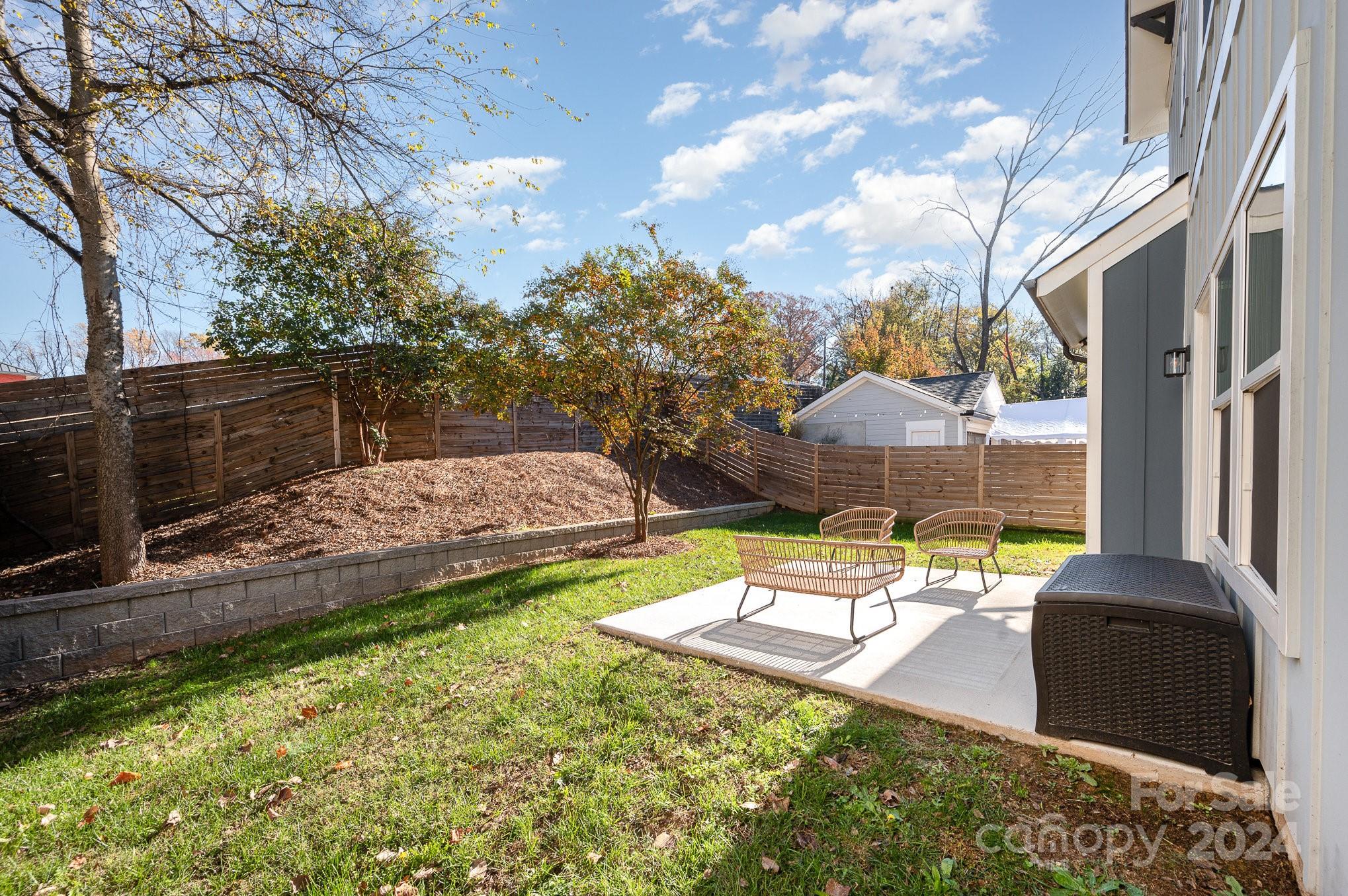643 Tennyson Drive Charlotte, NC 28208 - Photo 39 of 42 a view of a backyard with couches plants and large trees