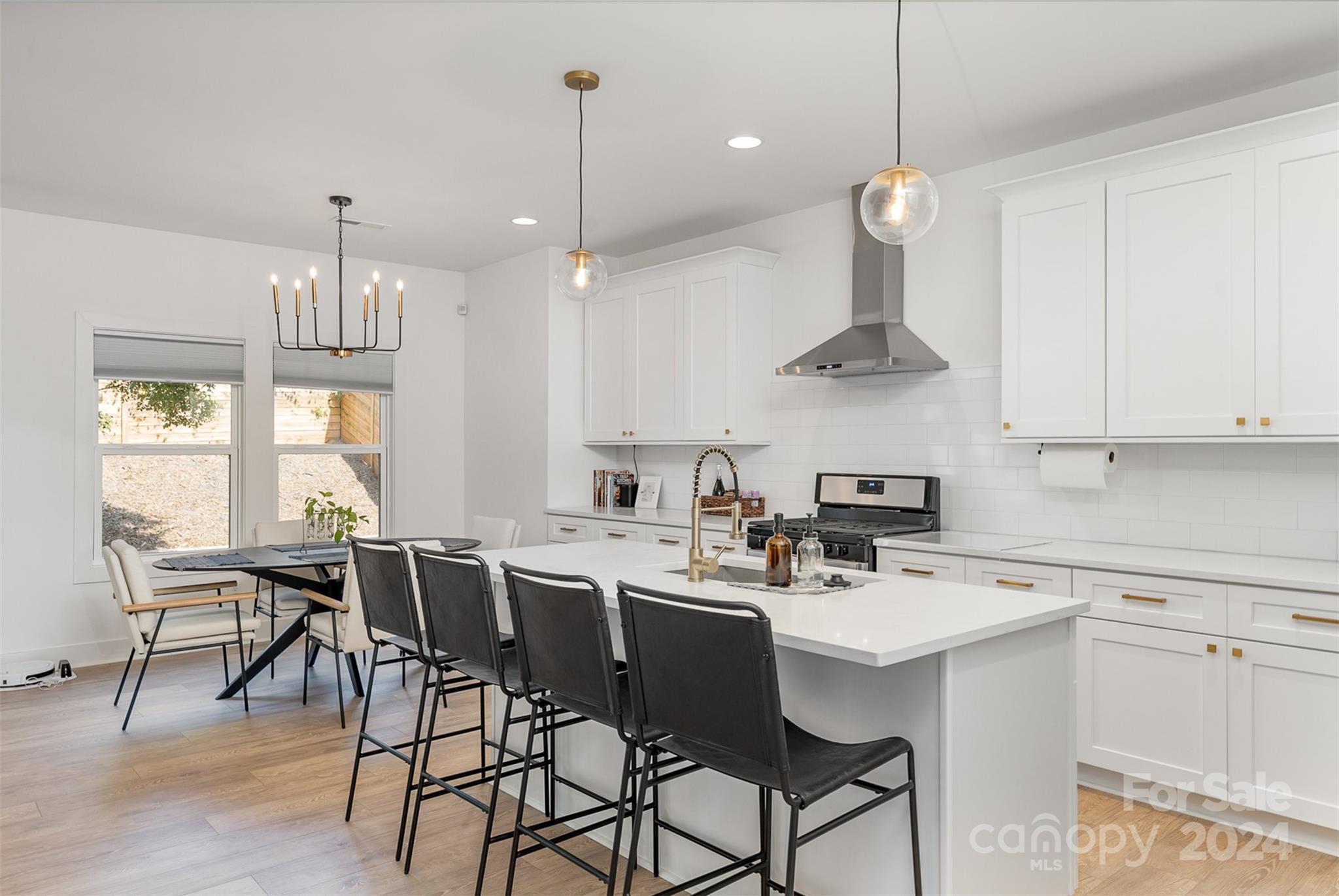 643 Tennyson Drive Charlotte, NC 28208 - Photo 6 of 42 a kitchen with a dining table chairs sink and cabinets