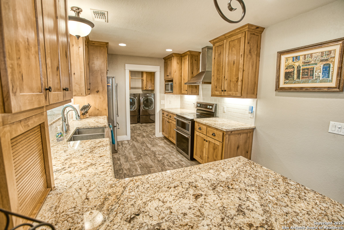 255 North Thunder Creek Road Utopia, TX 78884 - Photo 12 of 46 a kitchen with stainless steel appliances kitchen island granite countertop a sink and cabinets