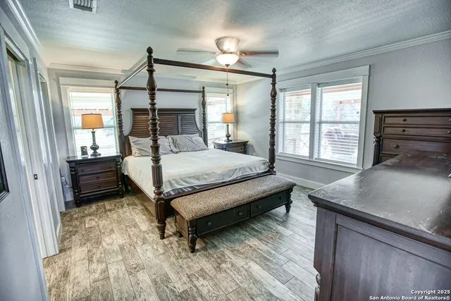 a bedroom with a bed dresser and a flat tv screen