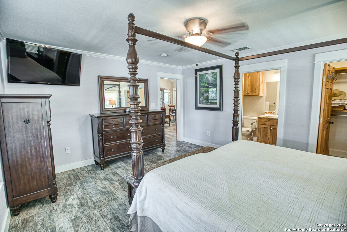 255 North Thunder Creek Road Utopia, TX 78884 - Photo 15 of 46 a bedroom with a bed dresser and a flat tv screen