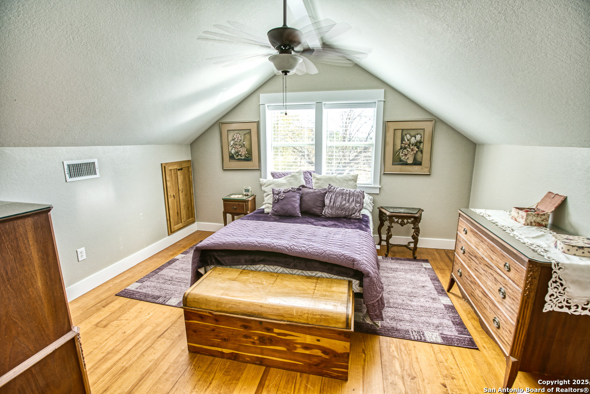 255 North Thunder Creek Road Utopia, TX 78884 - Photo 19 of 46 a bedroom with a bed and wooden floor