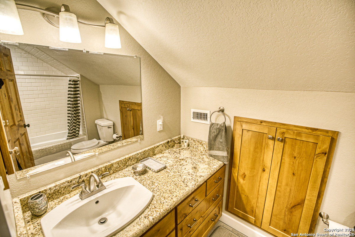 255 North Thunder Creek Road Utopia, TX 78884 - Photo 20 of 46 a bathroom with a granite countertop sink and a mirror