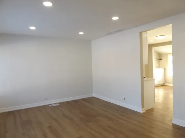 a view of empty room with wooden floor