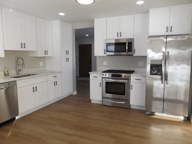 a kitchen with stainless steel appliances and white cabinets