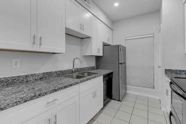a kitchen with stainless steel appliances granite countertop a refrigerator and a stove