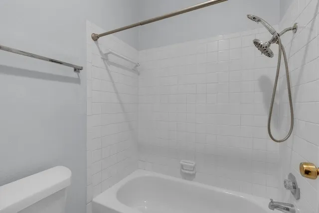a bathroom with a bath tub with a shower