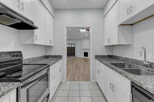 a kitchen with a sink stove top oven and cabinets