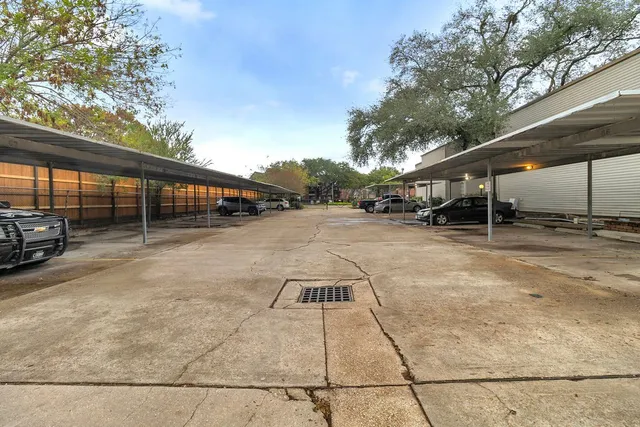 a view of a swimming pool with lawn chairs and iron fence