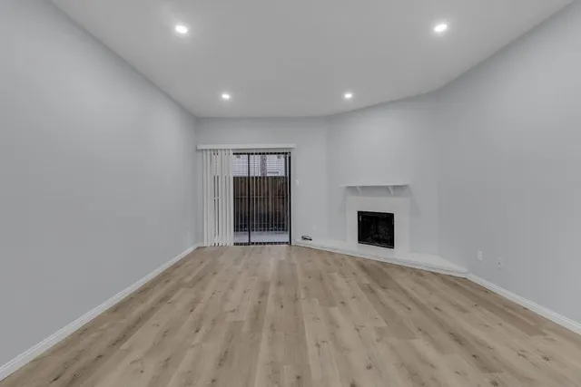 a view of an empty room with a fireplace and a window