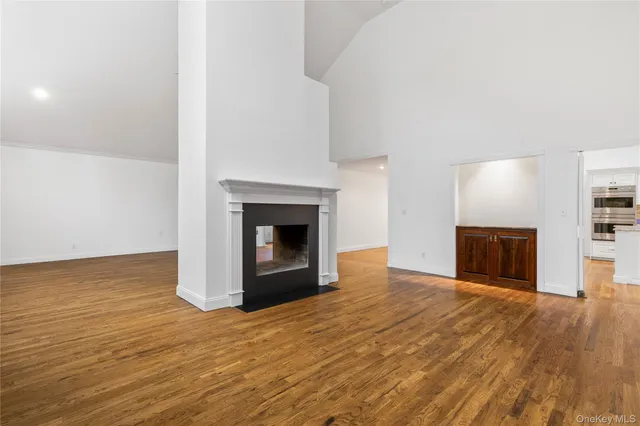 a view of empty room with wooden floor and fireplace