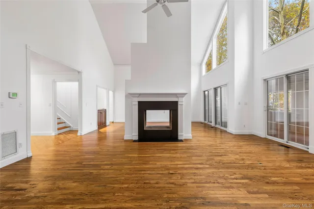 a view of empty room with wooden floor and fireplace