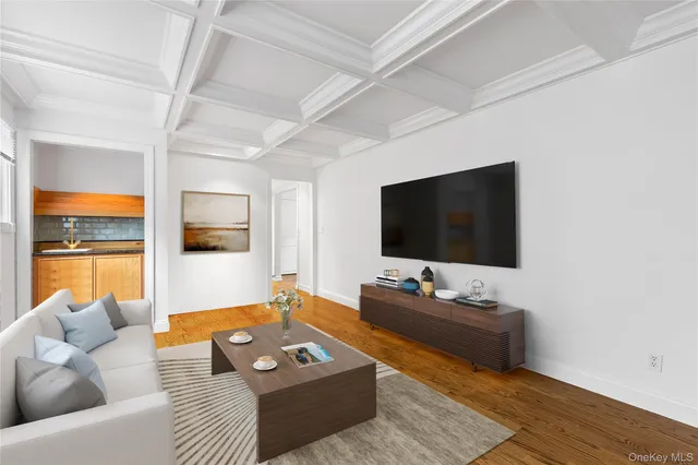 a view of an empty room with wooden floor fireplace and a window