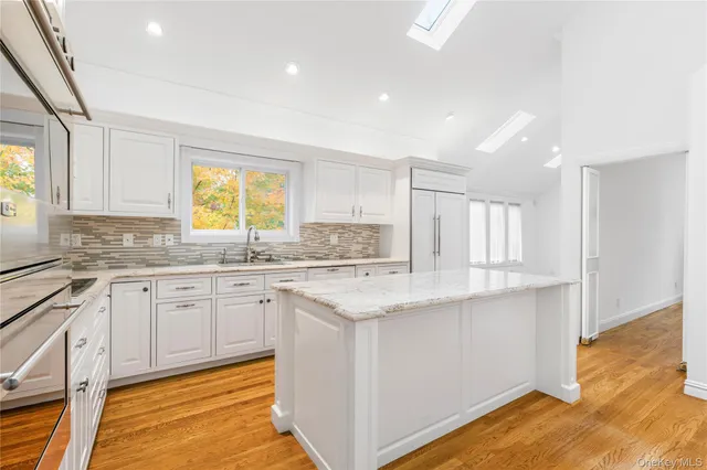 a kitchen with granite countertop sink stove and cabinets
