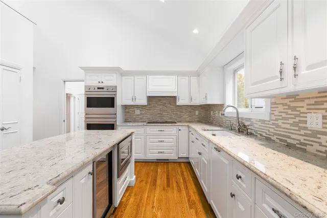 a kitchen with granite countertop a sink stove and cabinets