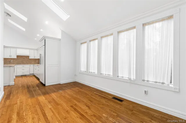 a view of a bedroom with wooden floor and windows