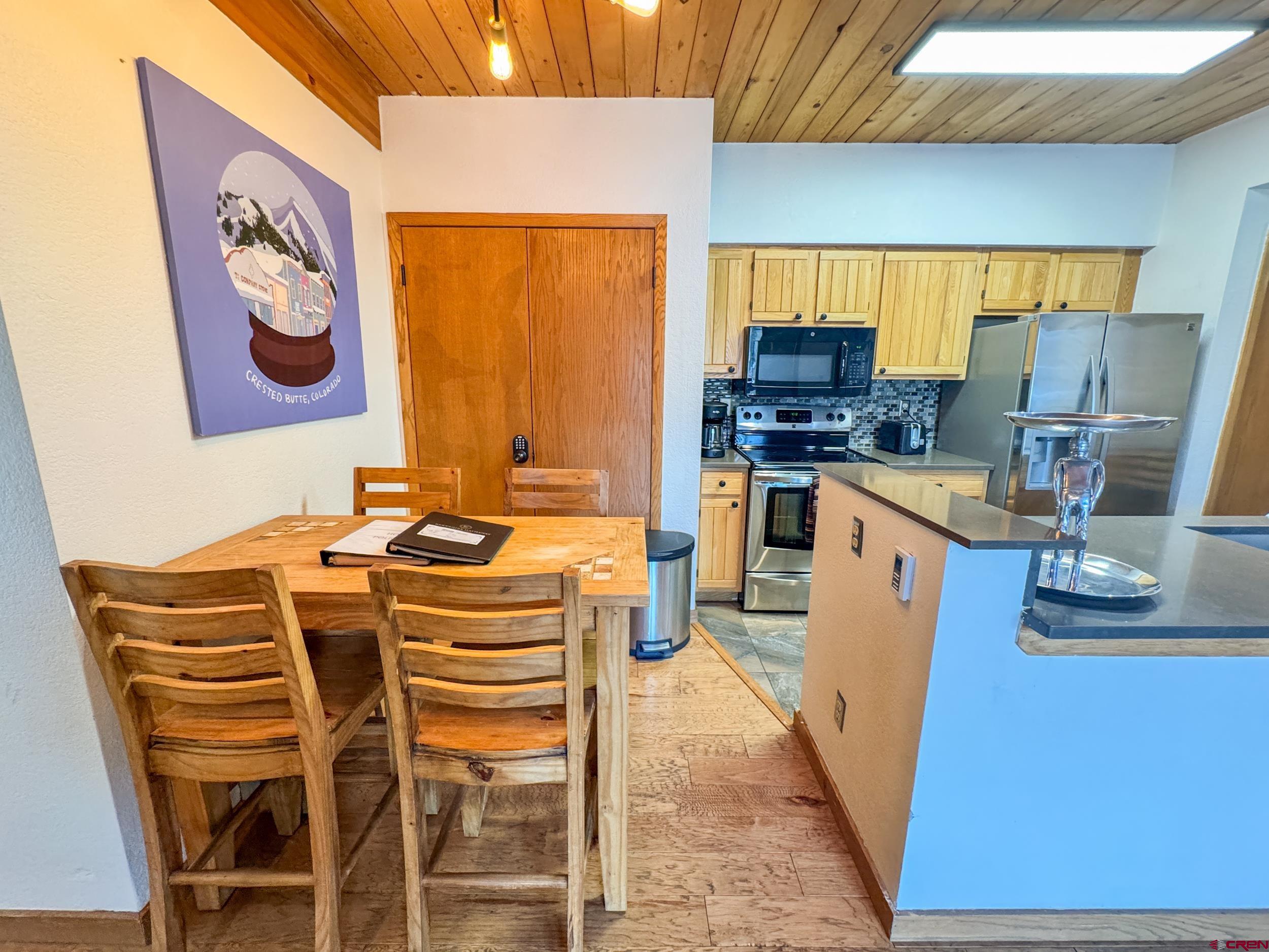 400 Gothic Road, Unit 305 Crested Butte, CO 81225 - Photo 11 of 38 a kitchen with stainless steel appliances kitchen island granite countertop a stove a sink and a microwave