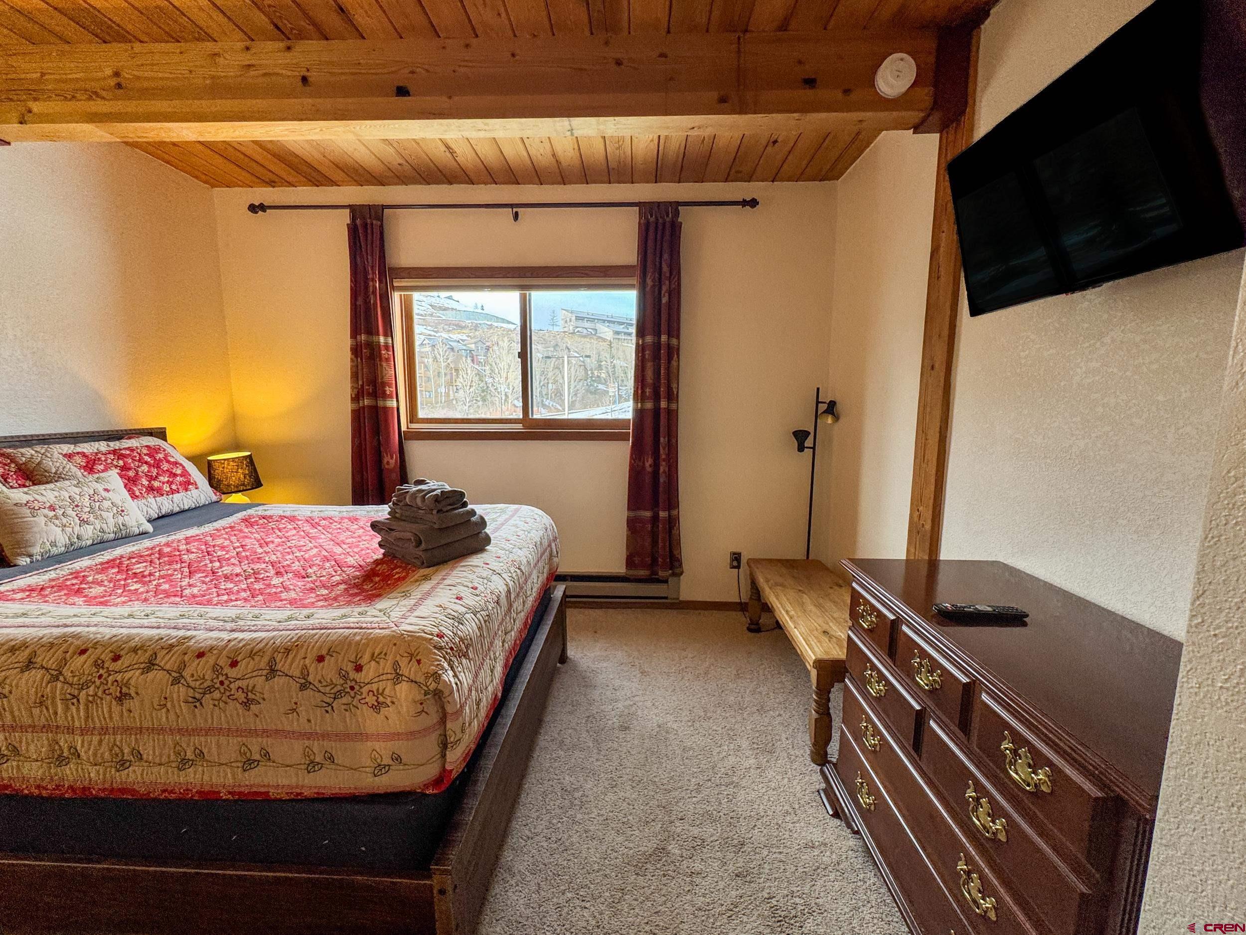 400 Gothic Road, Unit 305 Crested Butte, CO 81225 - Photo 17 of 38 a bedroom with a bed and a flat screen tv