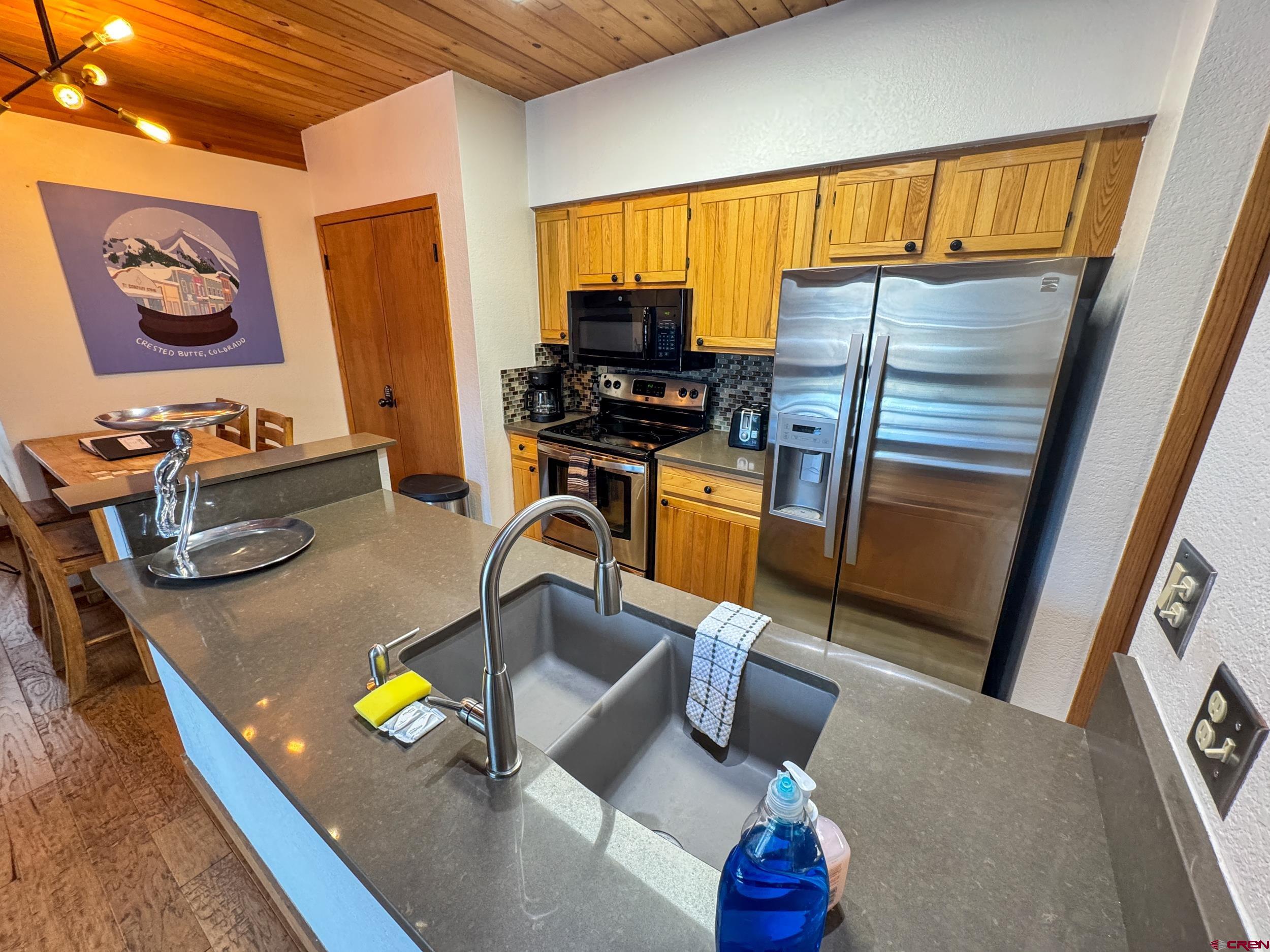 400 Gothic Road, Unit 305 Crested Butte, CO 81225 - Photo 6 of 38 a kitchen with refrigerator and sink