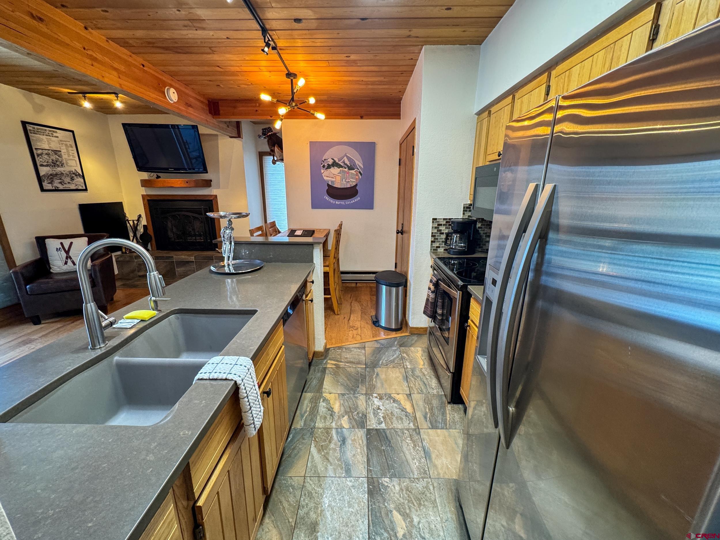 400 Gothic Road, Unit 305 Crested Butte, CO 81225 - Photo 7 of 38 a kitchen with stainless steel appliances granite countertop sink stove and refrigerator
