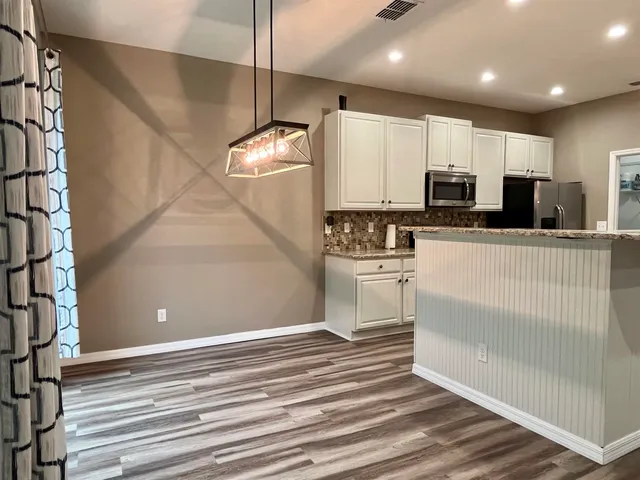 a kitchen with stainless steel appliances a refrigerator and a stove top oven