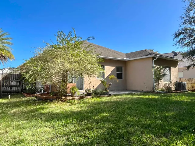 a backyard of a house with table and chairs