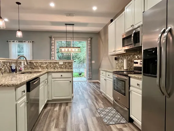 a kitchen with stainless steel appliances granite countertop a sink stove and refrigerator