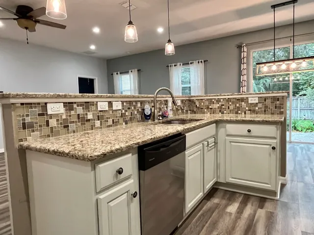 a kitchen with granite countertop a sink and cabinets