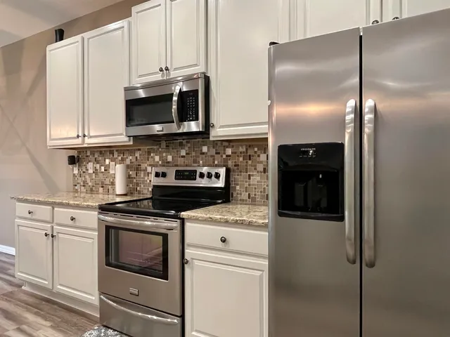 a kitchen with stainless steel appliances wooden cabinets and a stove