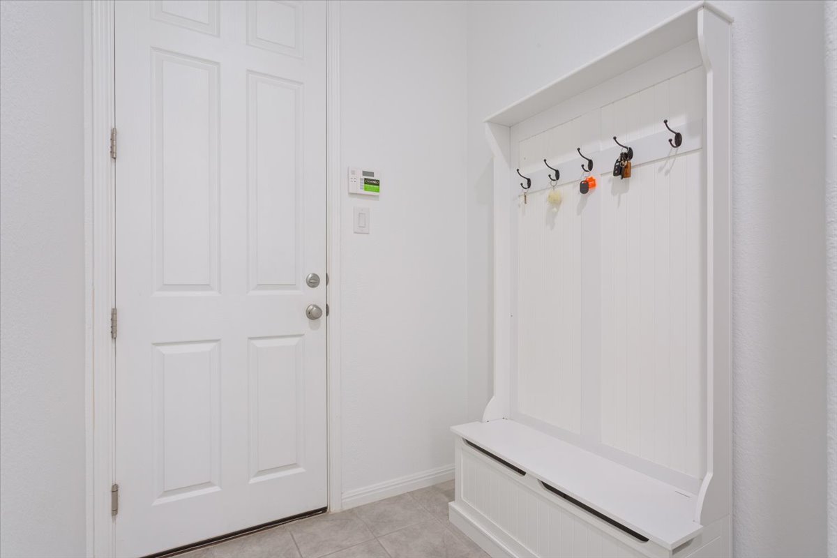 3625 Garrano Bend Leander, TX 78641 - Photo 28 of 38 A welcoming entryway from the 2 car garage with a practical mudroom bench and convenient coat hooks. The home has a seperate entrance to the third car garage.