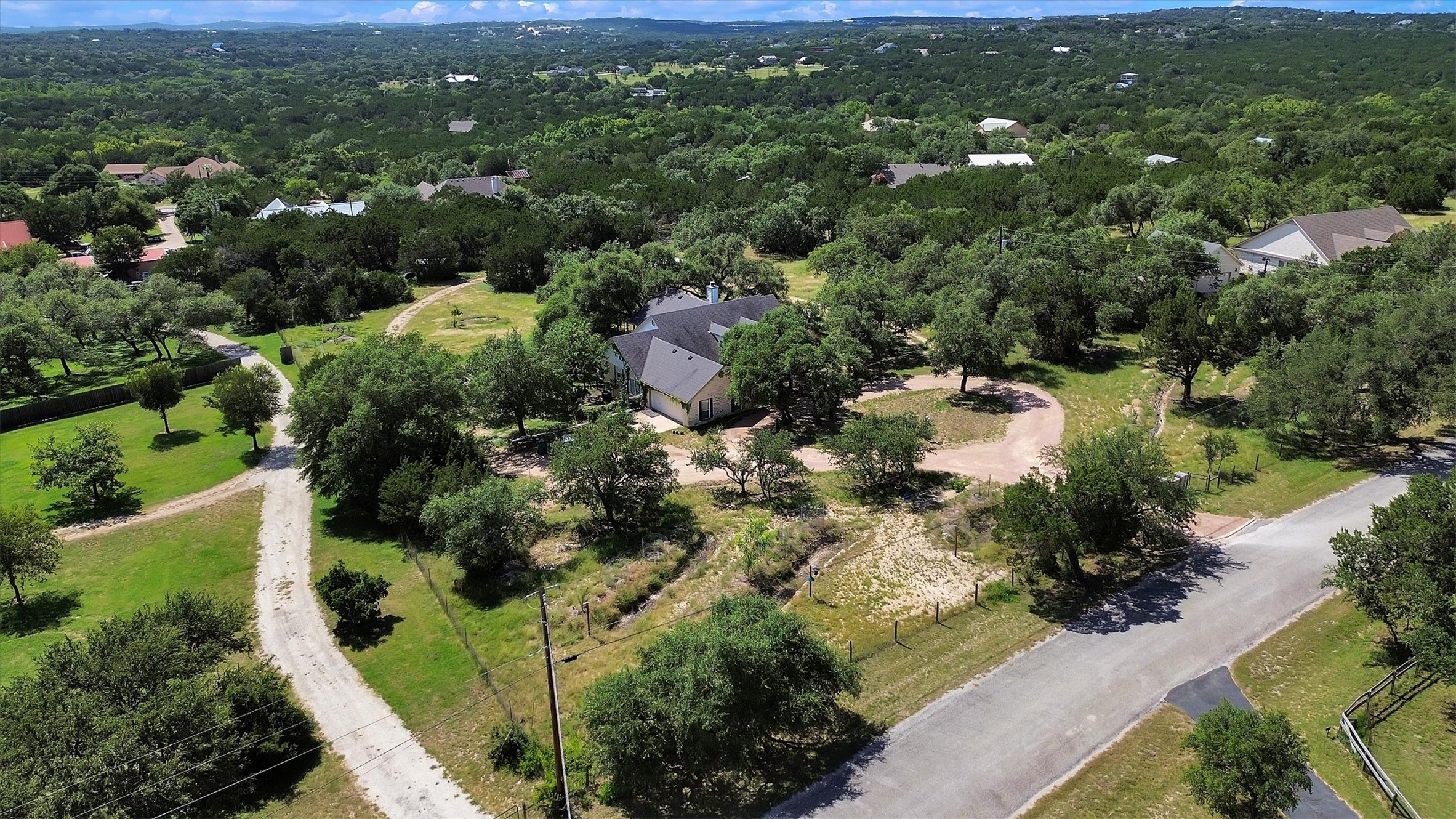 1120 Meadow Ridge Drive Austin, TX 78737 - Photo 35 of 40 An aerial panorama reveals a private estate nestled within a verdant, sprawling landscape.
