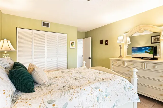 a bedroom with a bed and a large mirror