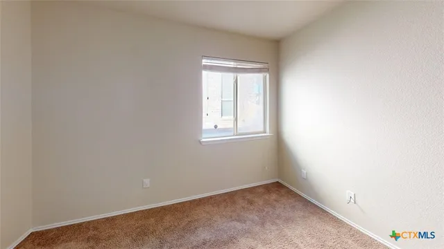an empty room with a chandeliers fan