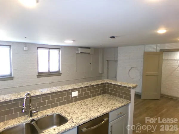 a bathroom with a granite countertop sink a toilet and bathtub
