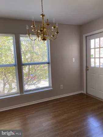 a utility room with wooden floor washer and dryer