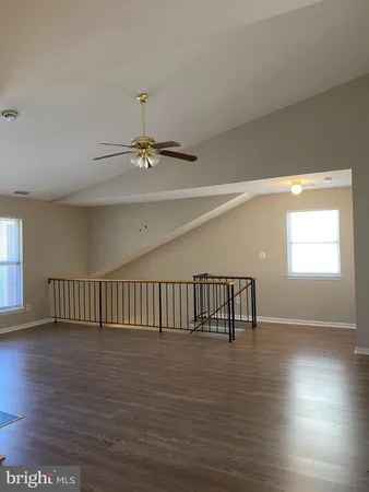 a view of empty room with wooden floor and fireplace