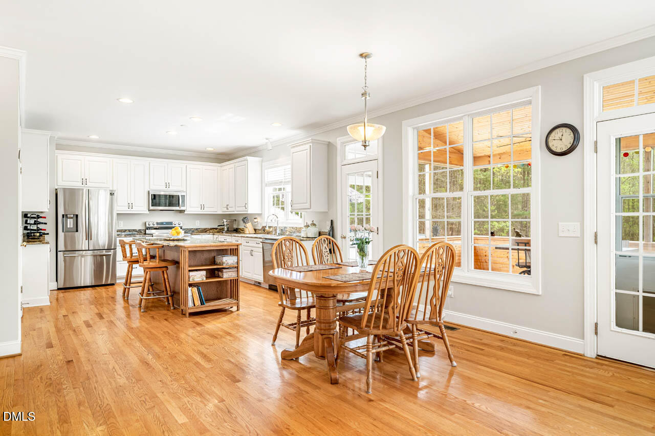 265 Old Chestnut Crossing Moncure, NC 27559 - Photo 12 of 45 a dining room with stainless steel appliances kitchen island granite countertop a dining table and chairs