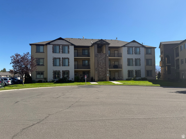 3618 Clear Rock Road, Unit 2 Eagle Mountain, UT 84005 - Photo 1 of 14 Three-story building with a stucco and stone veneer exterior, featuring multiple balconies with black railings