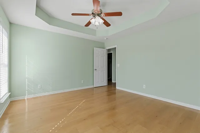 an empty room with chandelier fan