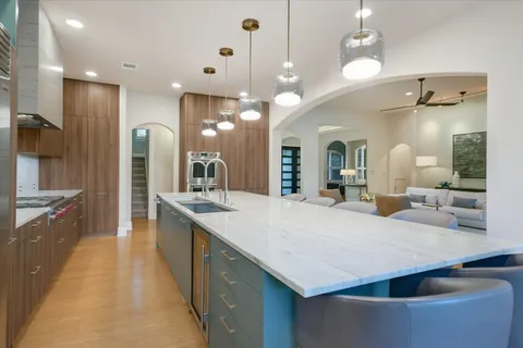 a large kitchen with kitchen island a sink and a large refrigerator